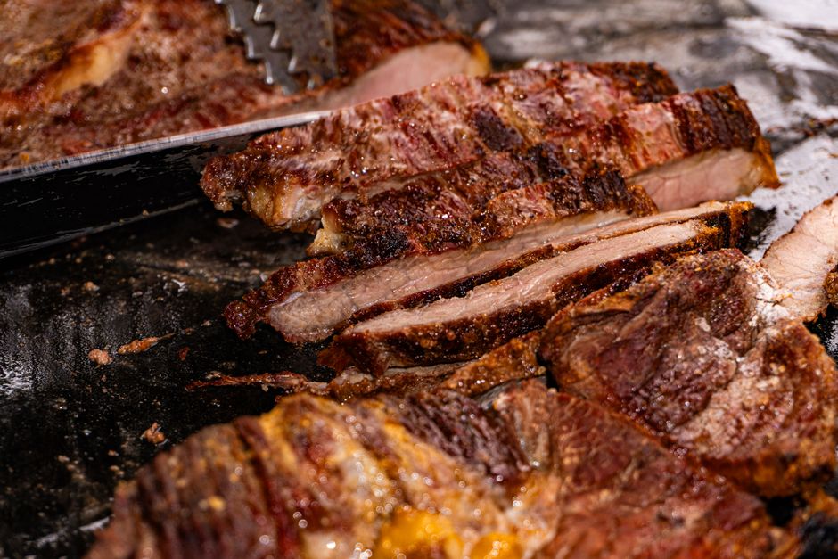 Bark-crusted smoked brisket sliced on a tray